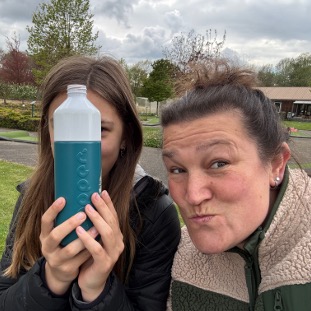 Carolien Lok met haar oudste dochter, speels verstopt achter een Dopper fles